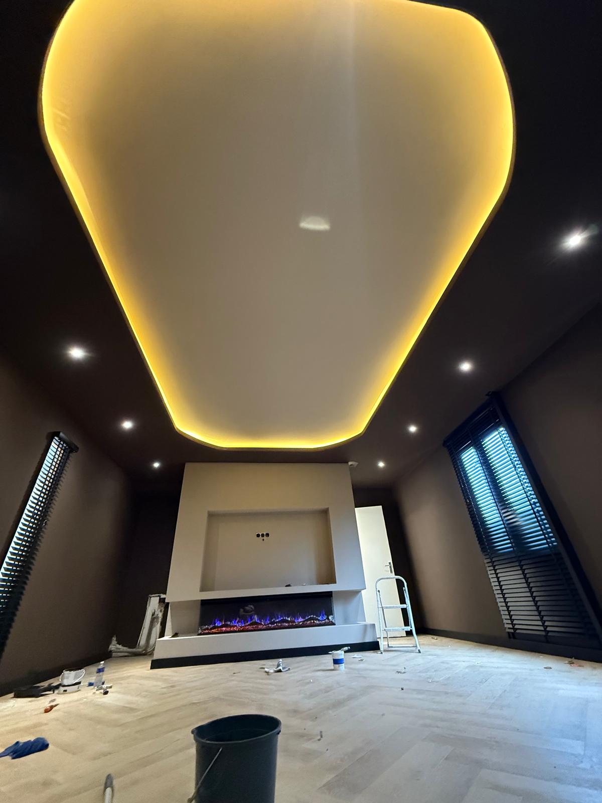 Gerenoveerde woonkamer met verlaagd plafond, sfeerverlichting en inbouwhaard