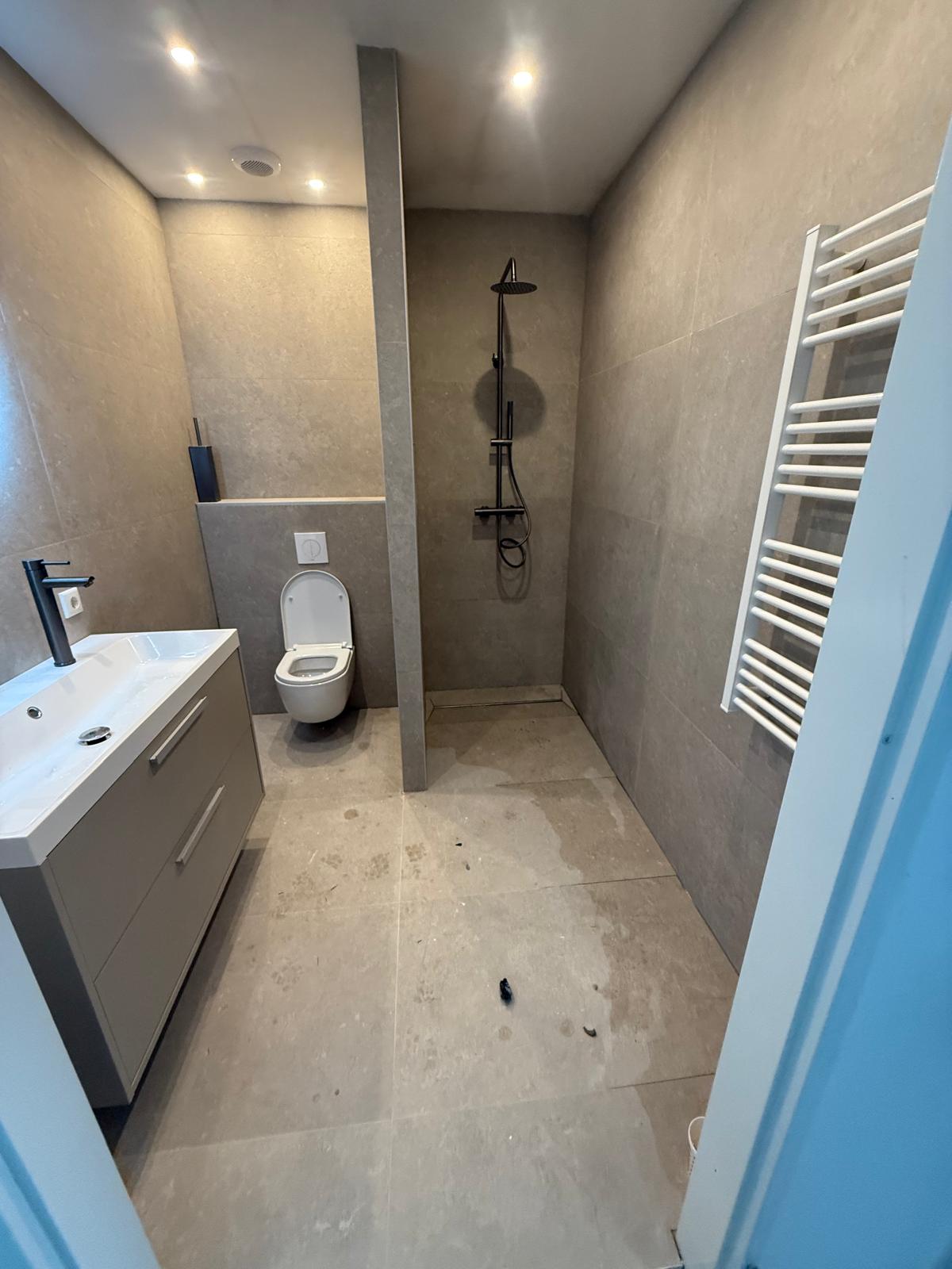 Gerenoveerde badkamer met betonlook tegels, inloopdouche en hangtoilet
